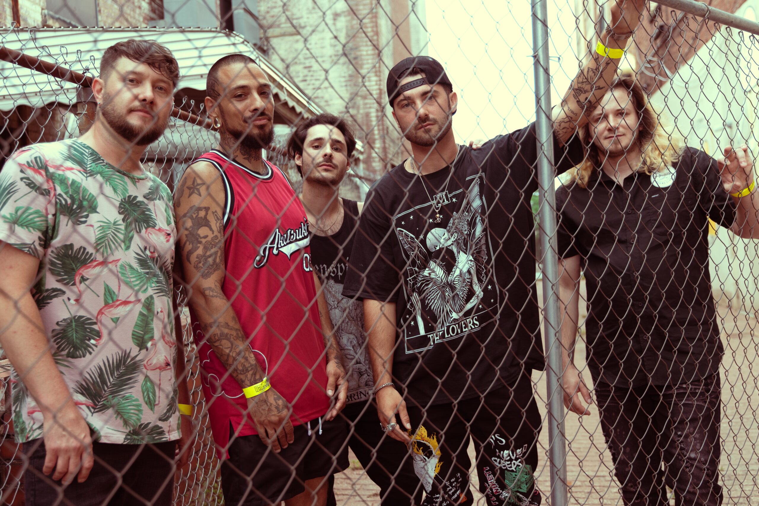 Vince Nerone and band standing behind chain-link fence